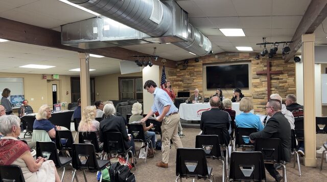 Attendees finding seats before the meeting at the Crossroads Community Center