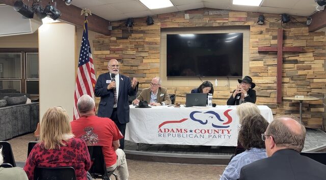 A candidate at the microphone beside the head table