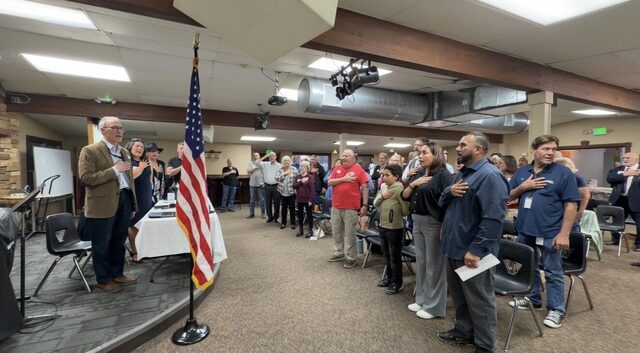 Attendees on their feet for the Pledge of Allegiance