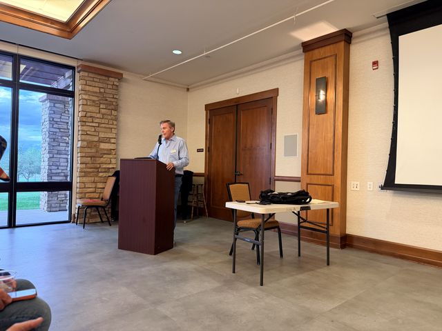 A speaker at the podium addressing the club