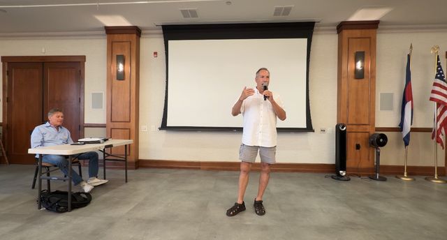 Paul speaking in front of the Colorado and American flags