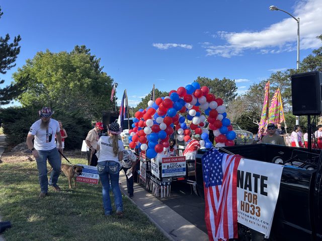 Volunteers and a dog beside the float, with a Nate for HD33 sign
