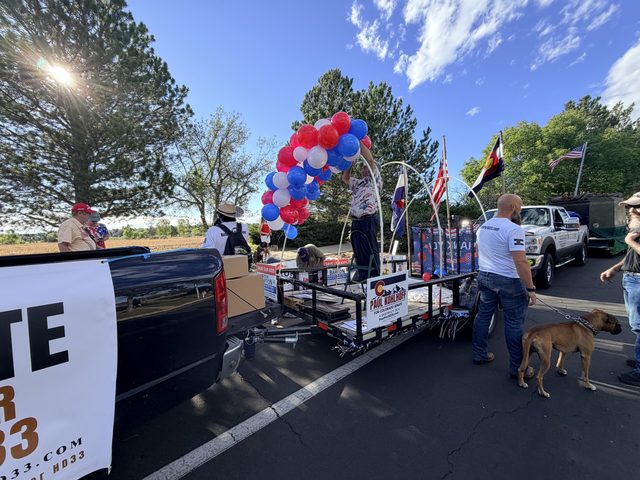 The float from behind, balloons up and signs going on