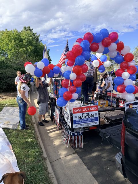 The red, white, and blue balloon arch going up on the float