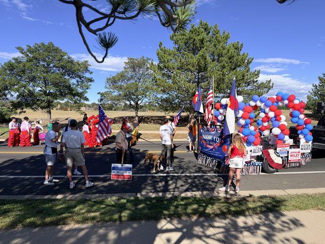 The group lined up with the float and flags